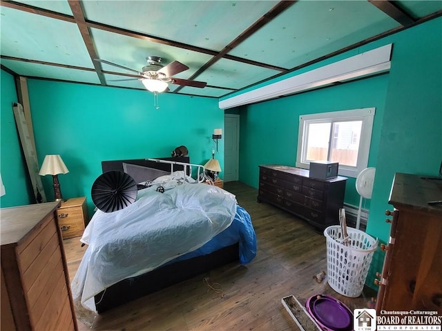 bedroom with a baseboard heating unit and dark wood-type flooring