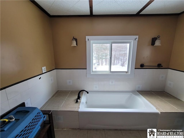 bathroom with tile walls, tile patterned floors, and a tub to relax in