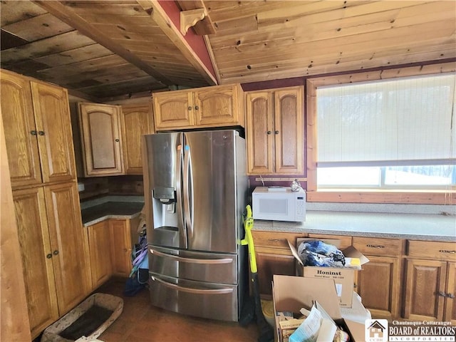 kitchen featuring vaulted ceiling, stainless steel fridge, and wood ceiling