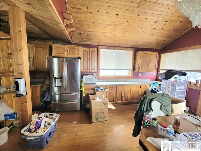 kitchen with vaulted ceiling, stainless steel fridge, light wood-type flooring, and wooden ceiling