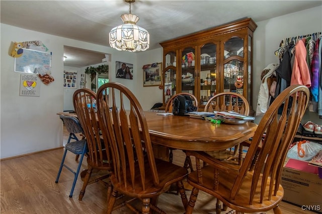 dining space with an inviting chandelier and light hardwood / wood-style floors