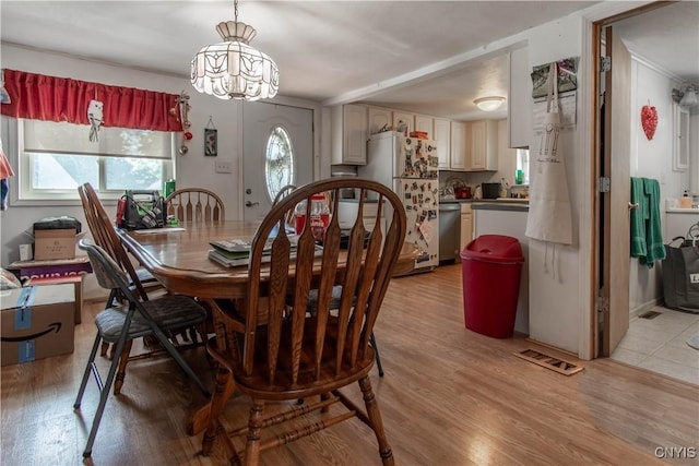 dining area with sink and light hardwood / wood-style floors