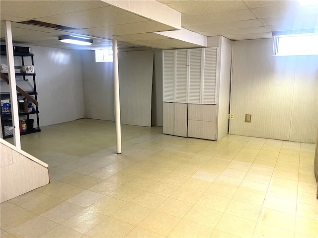 basement featuring a drop ceiling and a healthy amount of sunlight