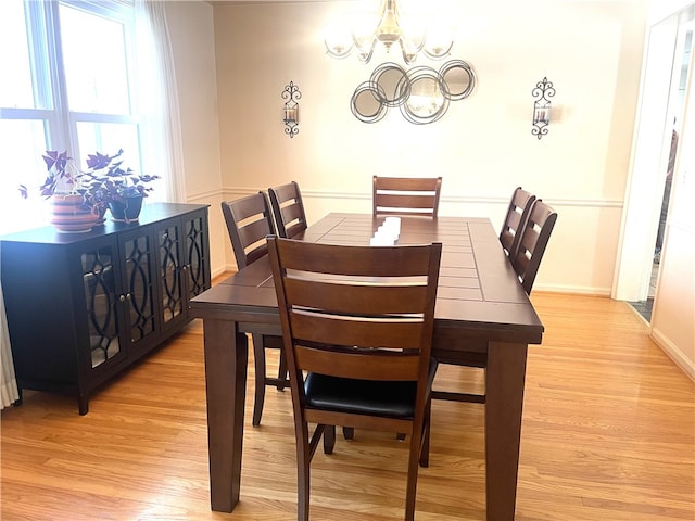 dining room with an inviting chandelier and light hardwood / wood-style flooring