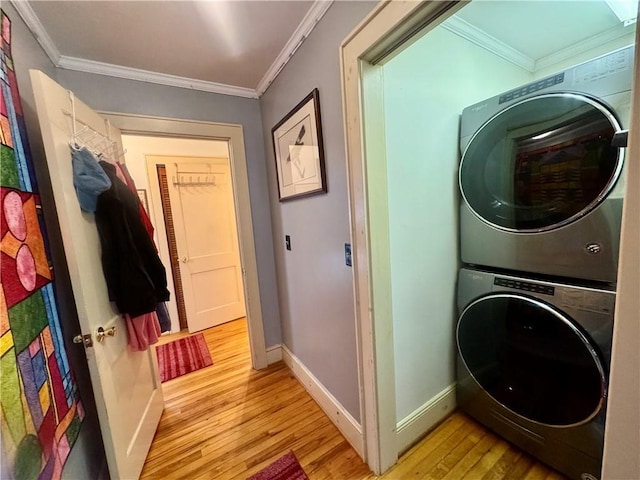 clothes washing area with stacked washer and dryer, crown molding, and light hardwood / wood-style floors