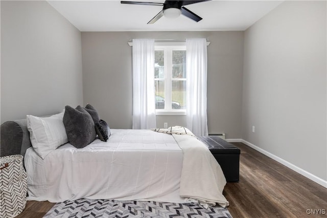 bedroom featuring a baseboard heating unit, dark wood-type flooring, and ceiling fan