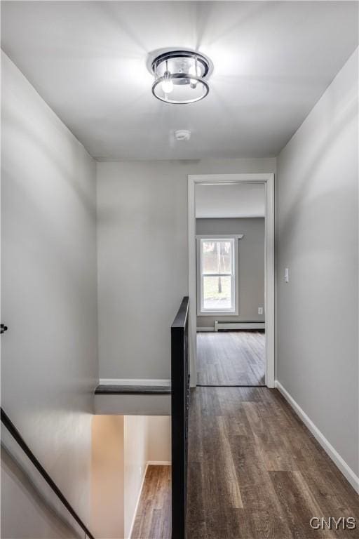 hallway featuring dark wood-type flooring and baseboard heating