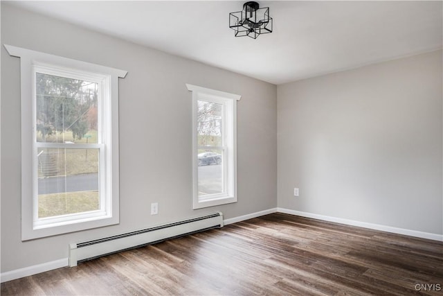 spare room featuring dark hardwood / wood-style floors and baseboard heating