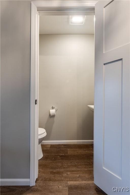 bathroom featuring wood-type flooring and toilet