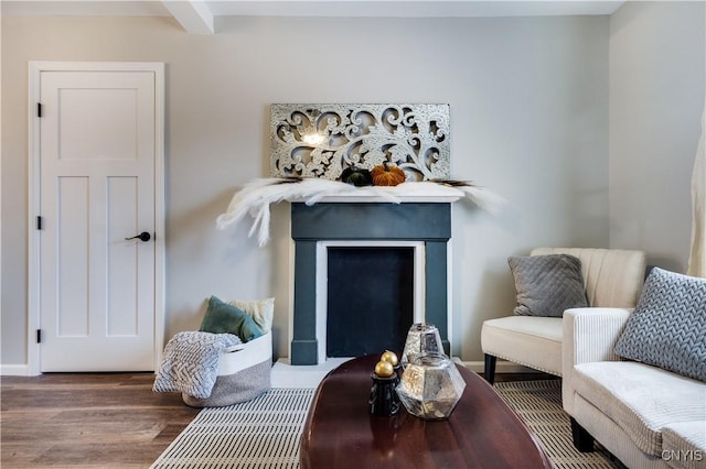 living area featuring dark wood-type flooring and beamed ceiling