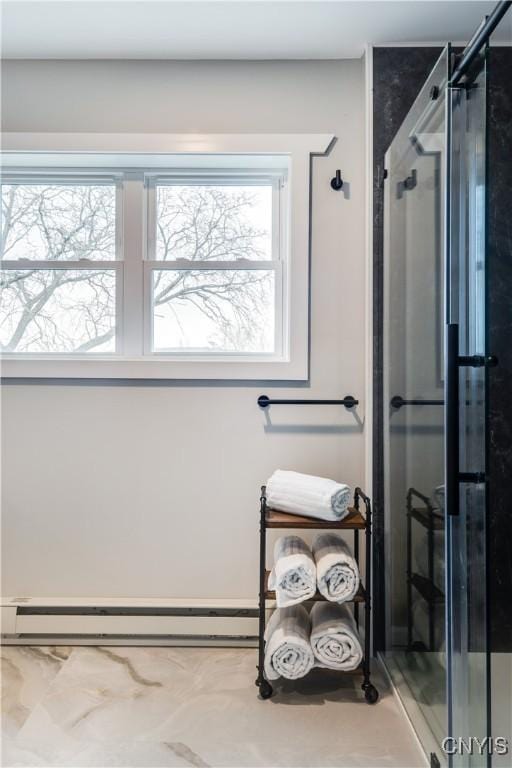 bathroom featuring baseboard heating and a shower with shower door