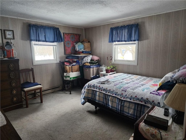 bedroom with a baseboard heating unit, carpet floors, and a textured ceiling