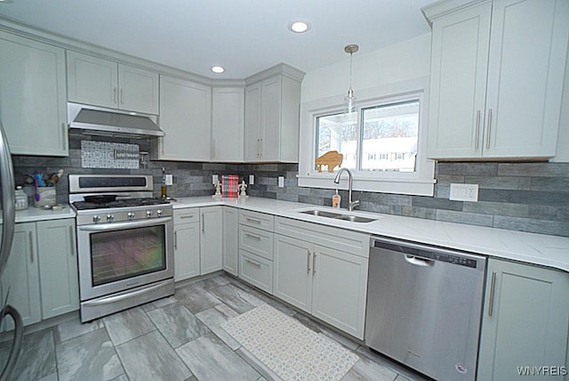 kitchen with gray cabinets, decorative light fixtures, sink, decorative backsplash, and stainless steel appliances