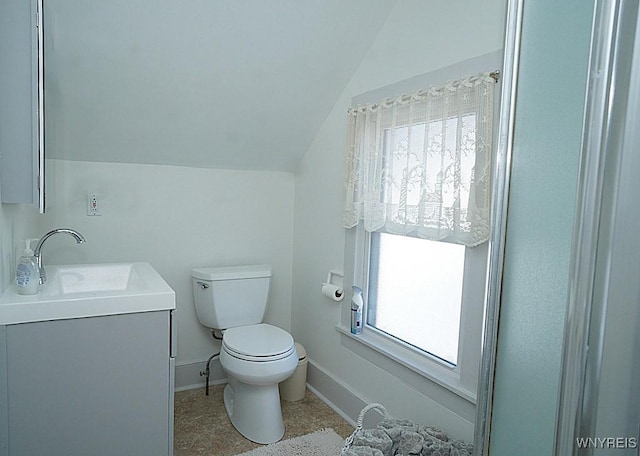 bathroom with vanity, lofted ceiling, and toilet