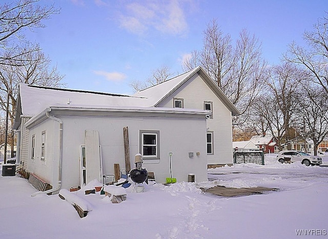 snow covered back of property with central AC unit