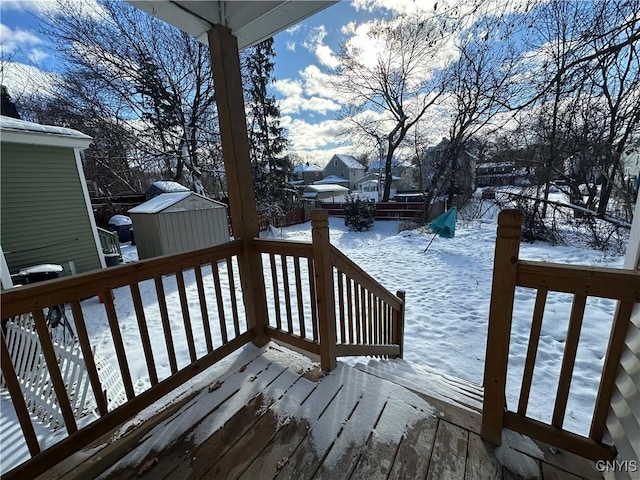 snow covered deck featuring a shed