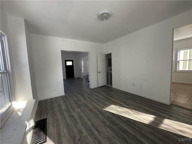 unfurnished room with dark wood-type flooring