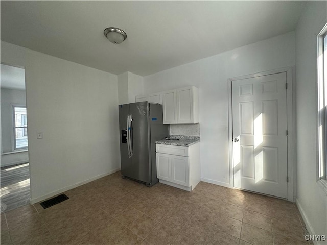 kitchen with white cabinetry, decorative backsplash, and stainless steel fridge with ice dispenser