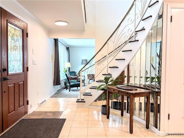 tiled entrance foyer featuring ornamental molding