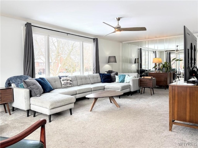 living room with crown molding, carpet flooring, and ceiling fan