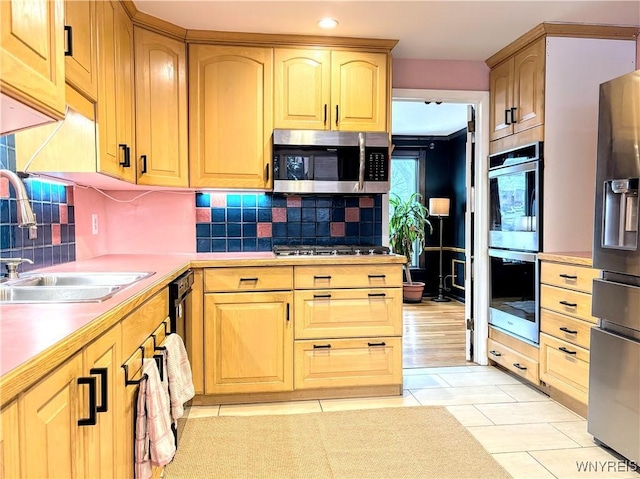 kitchen with appliances with stainless steel finishes, sink, and backsplash