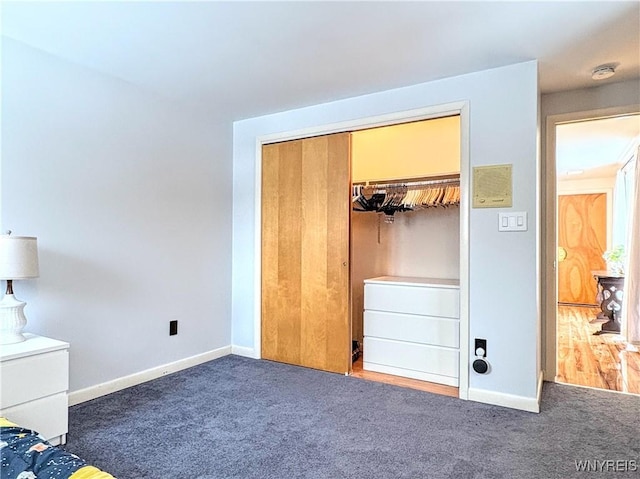 unfurnished bedroom featuring a closet and dark colored carpet