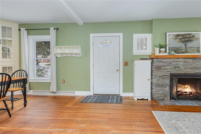 foyer featuring hardwood / wood-style floors, a fireplace, and beamed ceiling