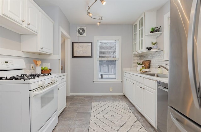 kitchen with white cabinetry, appliances with stainless steel finishes, sink, and decorative backsplash