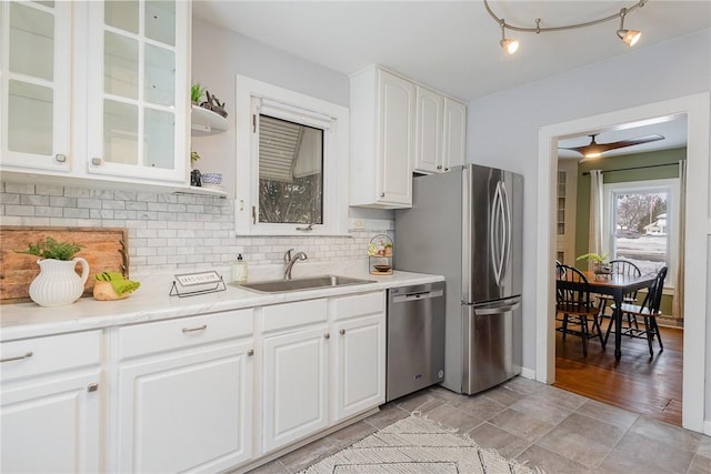 kitchen featuring sink, decorative backsplash, stainless steel appliances, and white cabinets