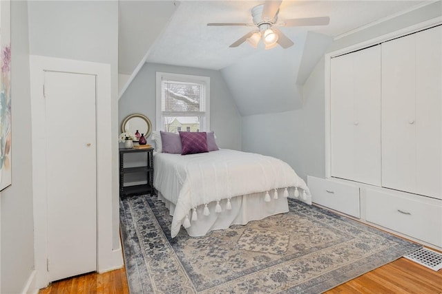 bedroom featuring light hardwood / wood-style flooring, a closet, ceiling fan, and vaulted ceiling