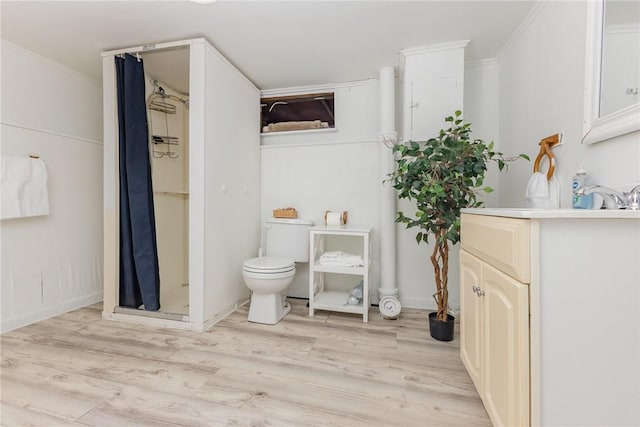 bathroom featuring vanity, toilet, hardwood / wood-style floors, and walk in shower