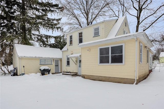 view of snow covered rear of property