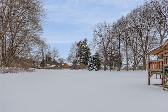 snowy yard featuring a playground