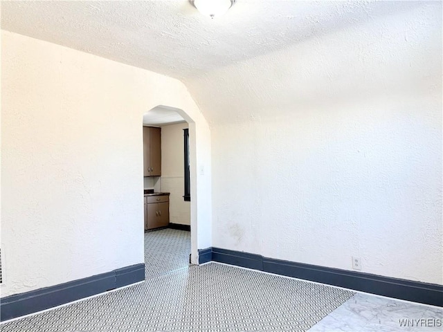 unfurnished room with a textured ceiling