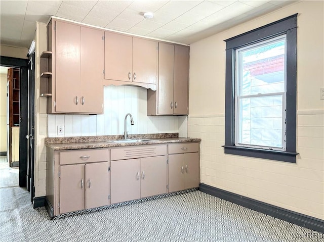 kitchen featuring sink, gray cabinetry, and tile walls