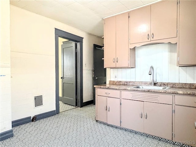 kitchen featuring sink and tile walls