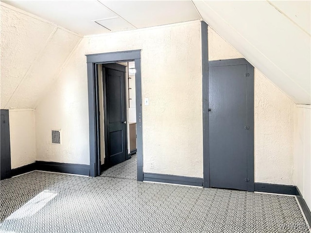 bonus room with vaulted ceiling and light colored carpet