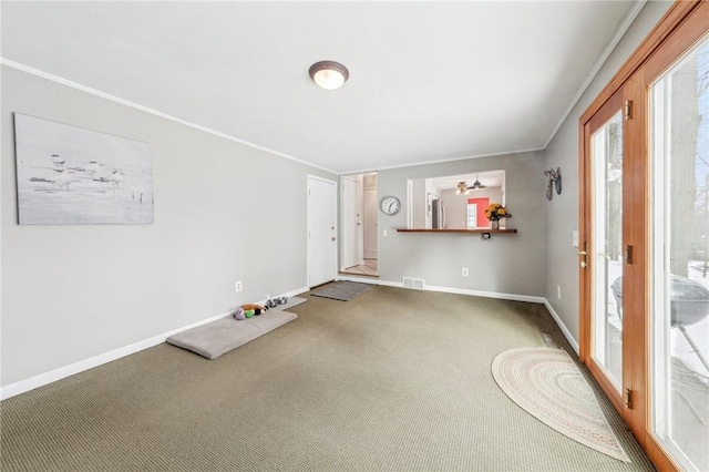 carpeted foyer featuring crown molding