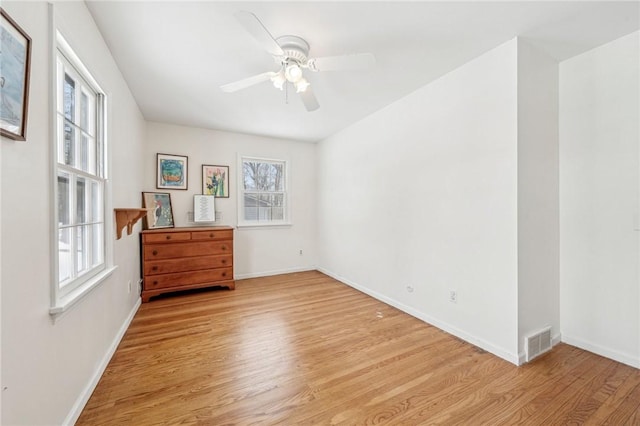 empty room with ceiling fan and light hardwood / wood-style floors