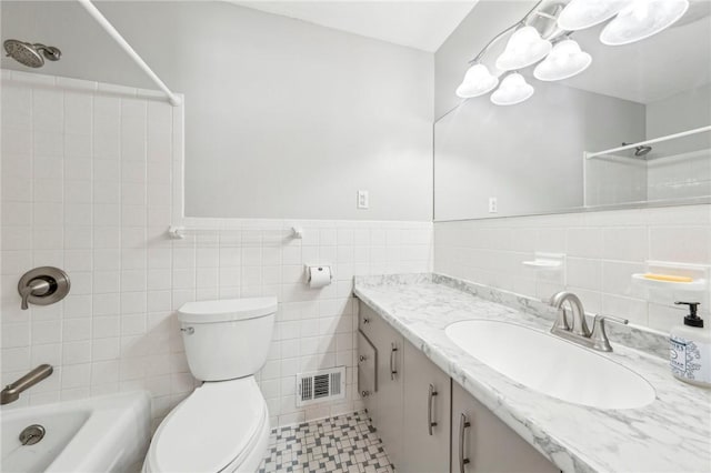 full bathroom featuring shower / tub combination, vanity, tile walls, and toilet