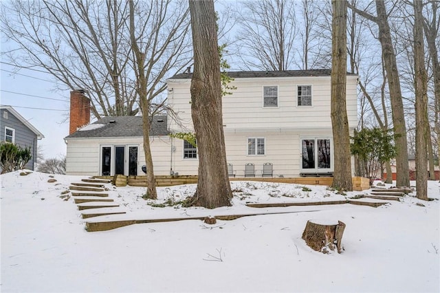 view of snow covered back of property