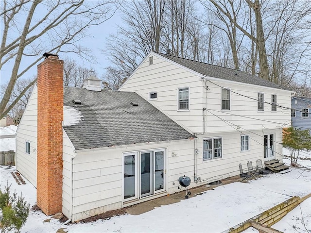 view of snow covered back of property