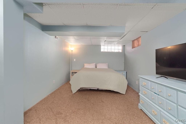 bedroom with light carpet and a paneled ceiling