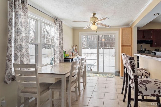 tiled dining room with crown molding, a textured ceiling, and ceiling fan