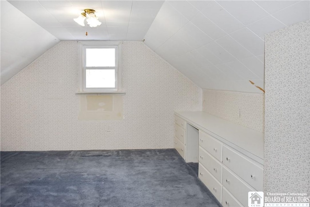 bonus room featuring lofted ceiling and dark carpet