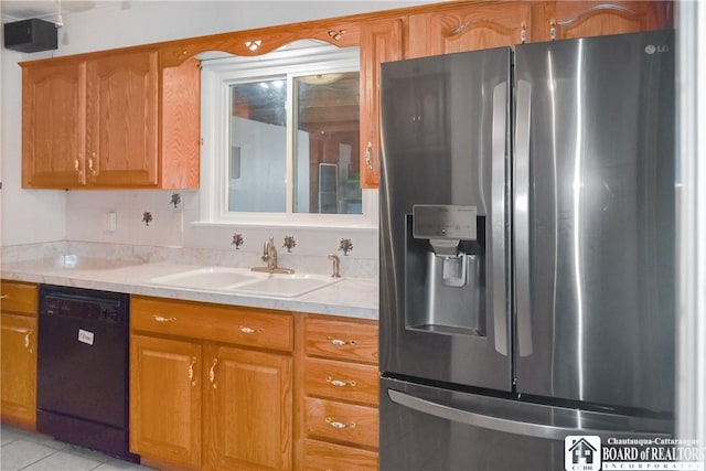 kitchen featuring sink, light tile patterned floors, dishwasher, and stainless steel refrigerator with ice dispenser