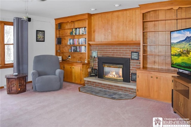 carpeted living room featuring built in shelves and a fireplace