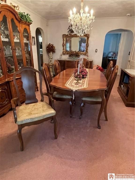 carpeted dining space featuring a notable chandelier and ornamental molding