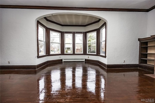 unfurnished room featuring crown molding, wood-type flooring, and a baseboard heating unit