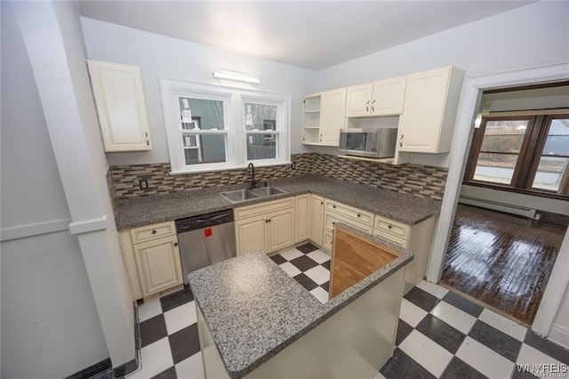 kitchen with tasteful backsplash, appliances with stainless steel finishes, sink, and baseboard heating